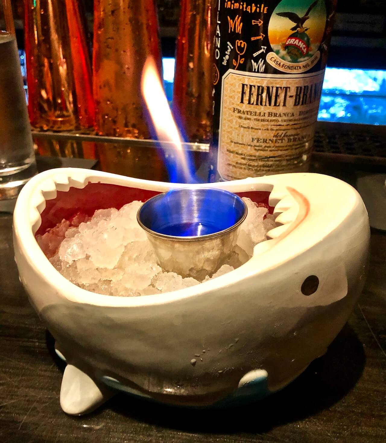 Flaming tiki drink in shark bowl