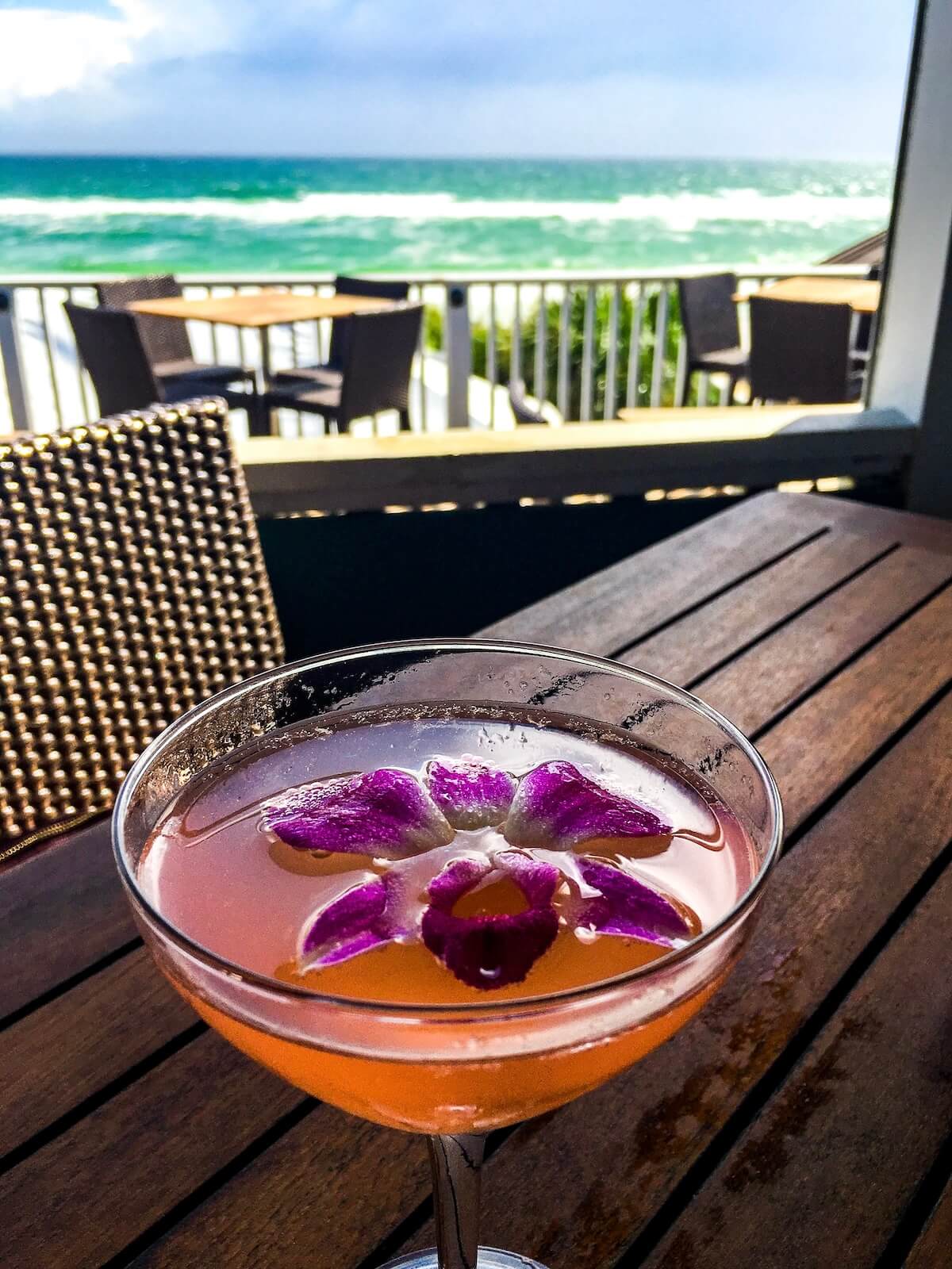 Pink cocktail on rooftop bar with ocean view