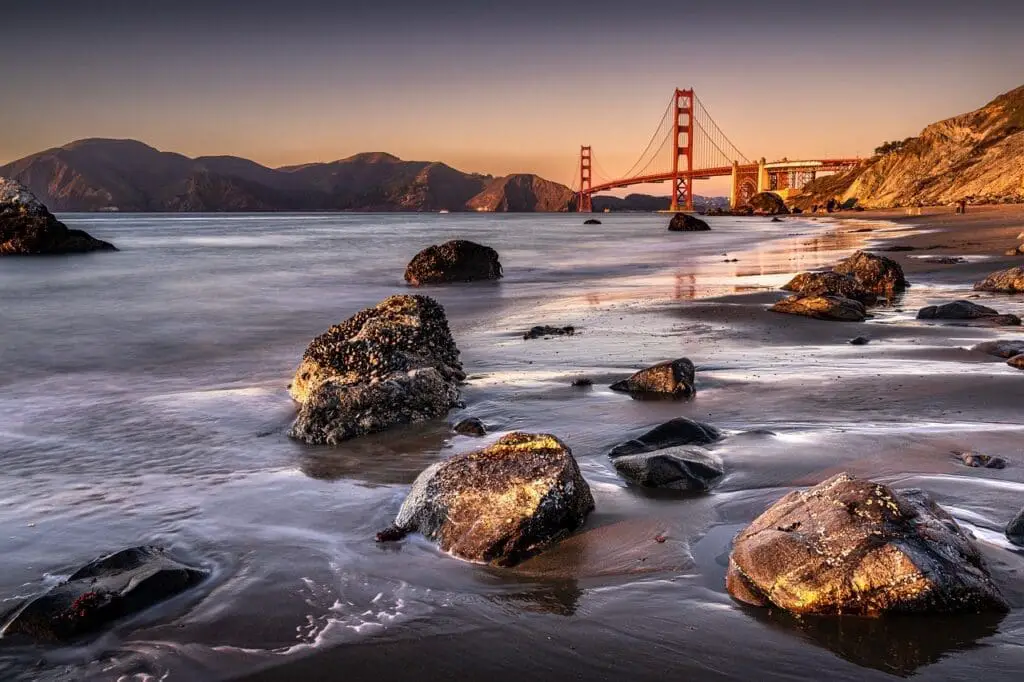 Rocky beach with golden gate bridge in the distance